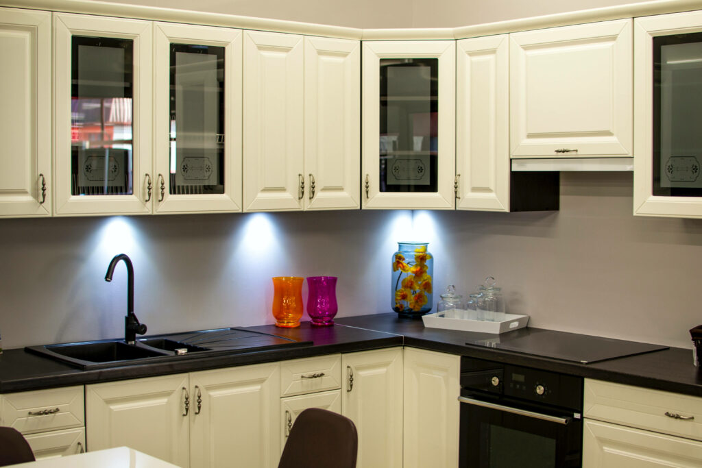 Sleek Contrast: A White Kitchen with Black Countertop Illuminated by Proper Lighting Wallpaper
