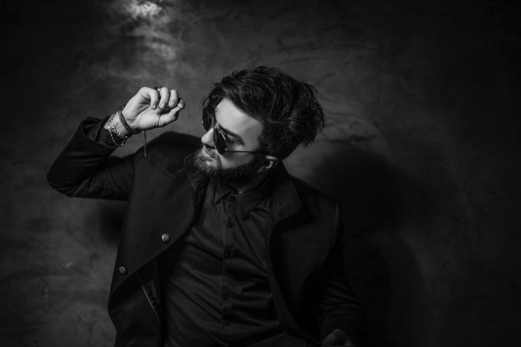 Captivating Charisma: A Striking Male Model Showcasing Timeless Style in a Monochrome Studio Portrait Wallpaper