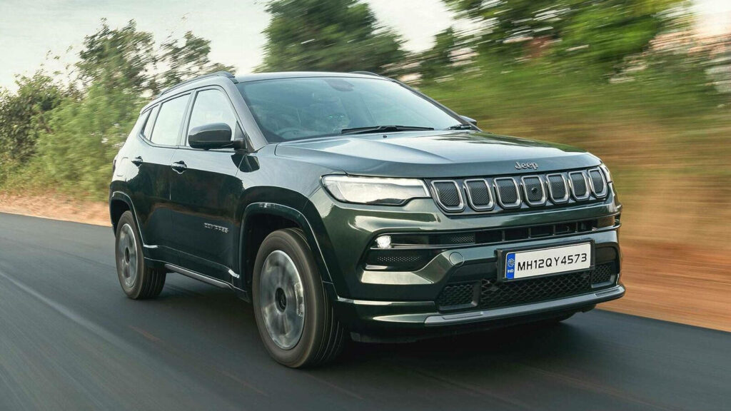 Jeep Compass speeding on road with blurred background showcasing power and sleek design wallpaper