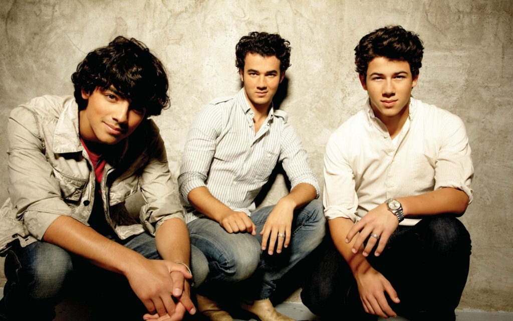 Stylish Jonas Brothers Wallpaper: Timeless Sibling Posing Background