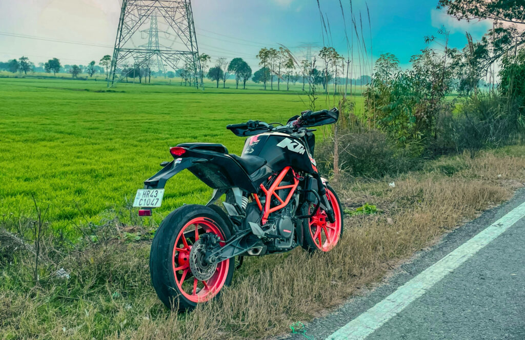 Stylish KTM Duke 200 Wallpaper: Motorbike in Lush Green Field