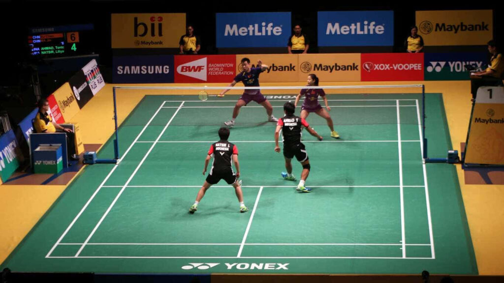 Skilled Badminton Players Engage in a Breathtaking Match against a Striking 1366x768 Backdrop Wallpaper