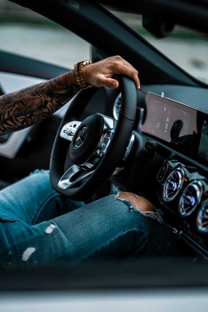 Stylish Mercedes Interior with Tattooed Hand on Elegant Steering Wheel Wallpaper