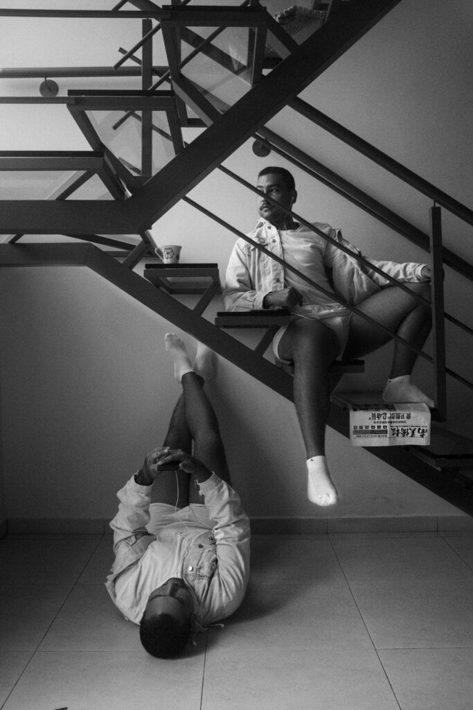 Monochrome Staircase Art: Two Individuals in Creative Pose Wallpaper