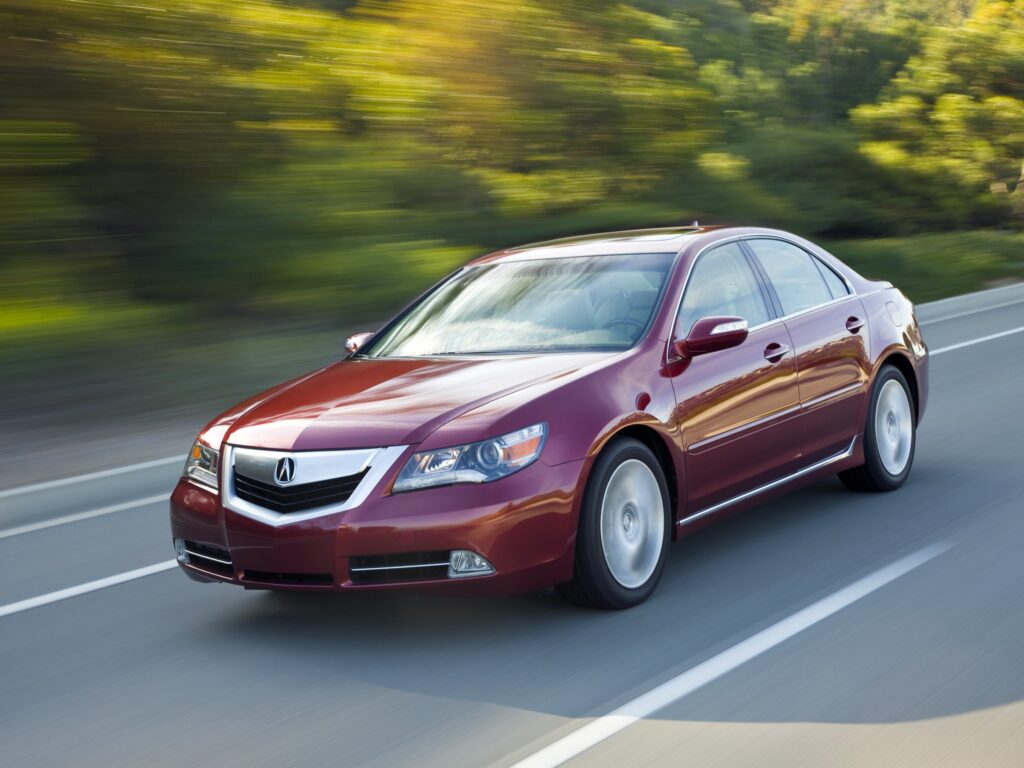 Stylish Red Acura RL Sedan: Sleek Design on Scenic Asphalt Road Wallpaper