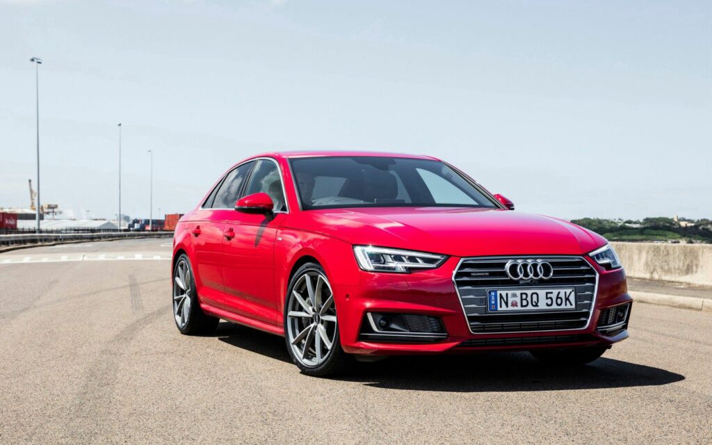 Sleek Red Audi A4 Side View Wallpaper on Clear Day Background