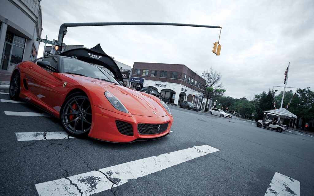 Stylish Red Ferrari at Urban Intersection: Sleek Design & Modern Backdrop Wallpaper