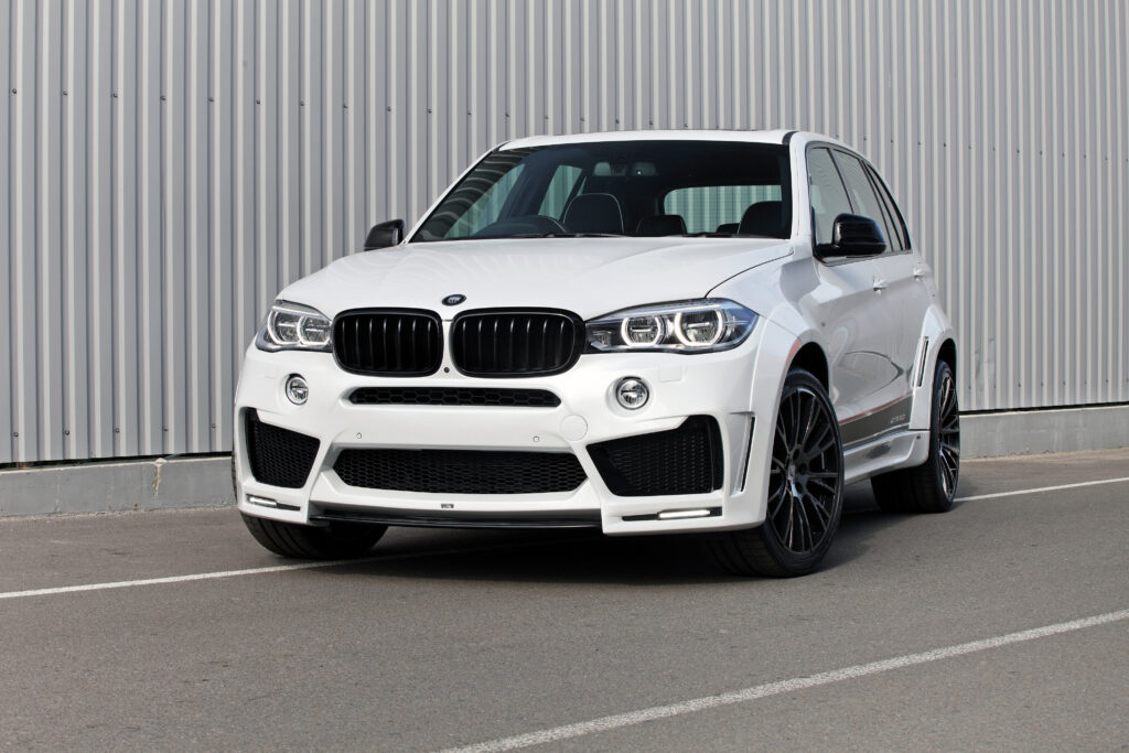 Elegant White BMW F15 Against Modern Metal Background Wallpaper