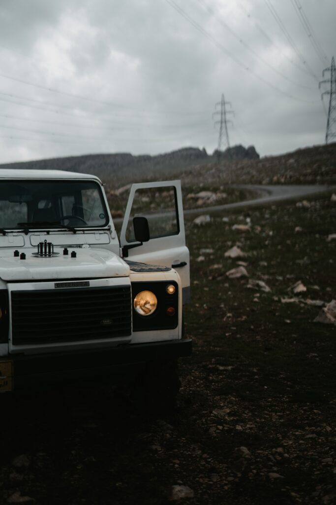 Adventure Awaits: Rugged White Land Rover Defender on Rocky Road Wallpaper