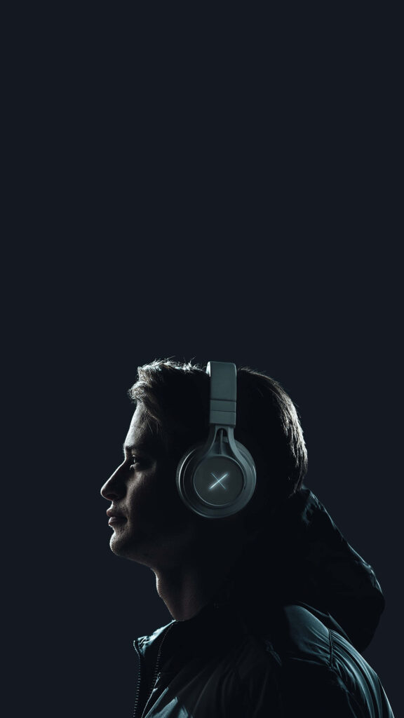 Sleek Wireless Headphones: Stylish Man's Profile on Dark Background Wallpaper