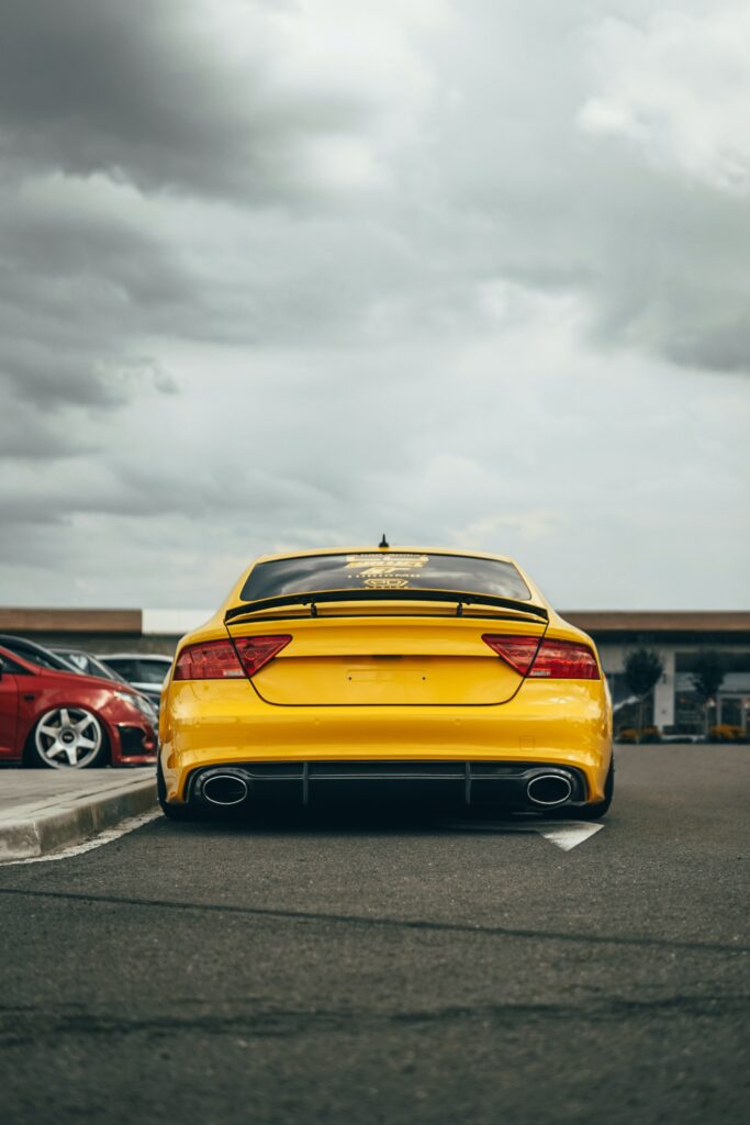 Yellow Audi Car Wallpaper: Sporty Design on a Dramatic Road