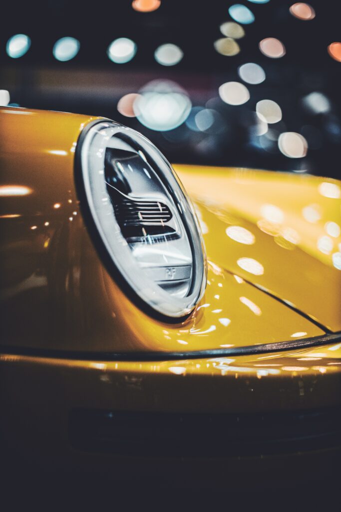Stylish Yellow Car Headlight Close-Up with Bokeh Background Wallpaper
