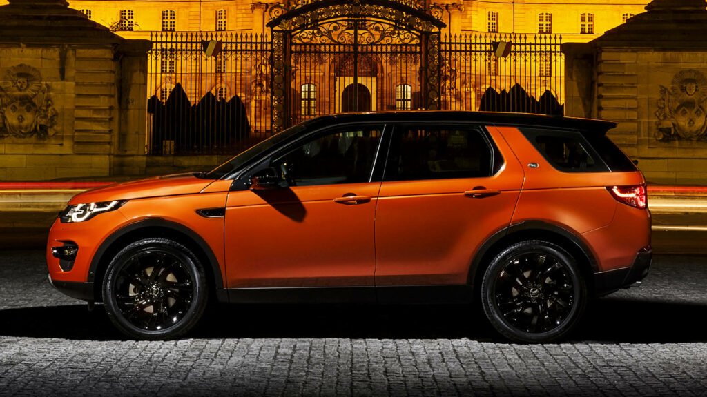 Vibrant Orange Land Rover Discovery: Sleek Wallpaper Background
