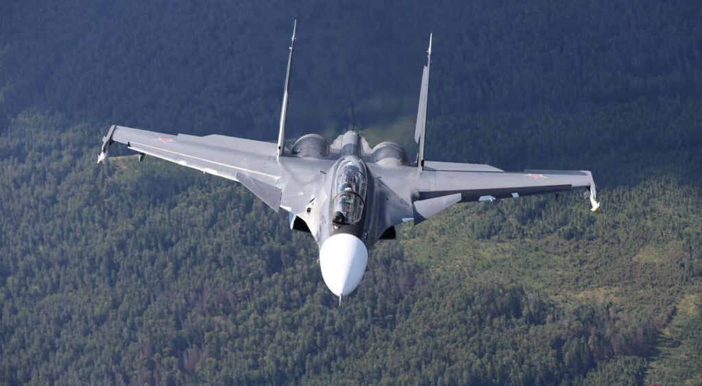 Sukhoi Su-30 Dominating Daytime Skies over Forested Wilderness Wallpaper