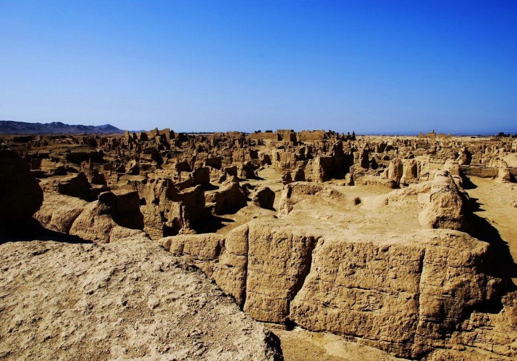 Sun-baked canyon labyrinth with rugged sandstone walls under clear blue sky desert landscape wallpaper