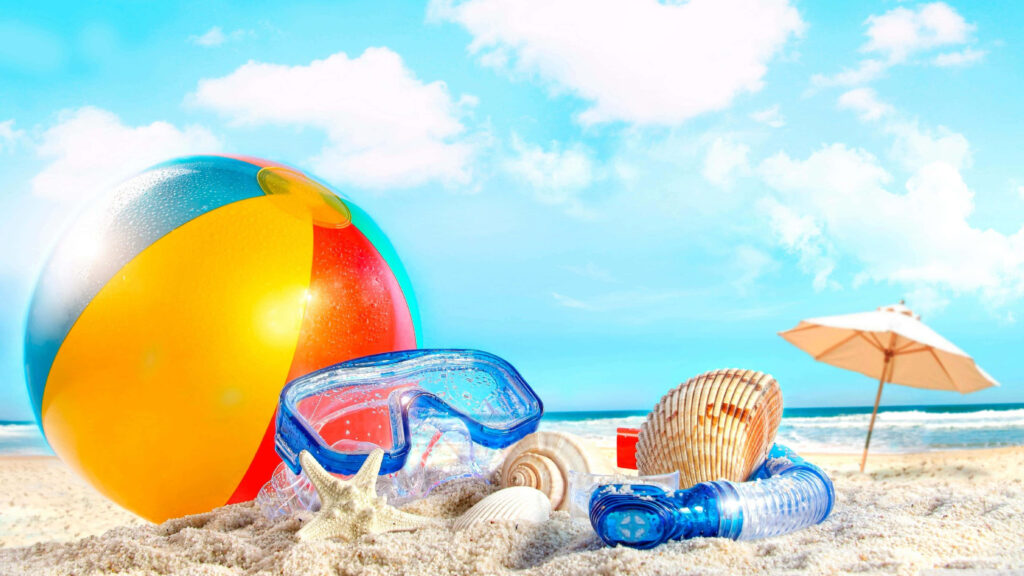 Vibrant beach ball snorkeling gear seashells starfish on white sand sunny ocean wallpaper background