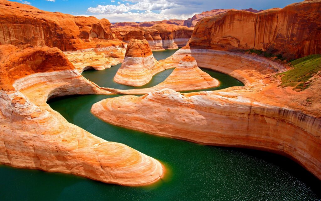 Vibrant canyon wallpaper with winding green river and towering orange sandstone rock formations