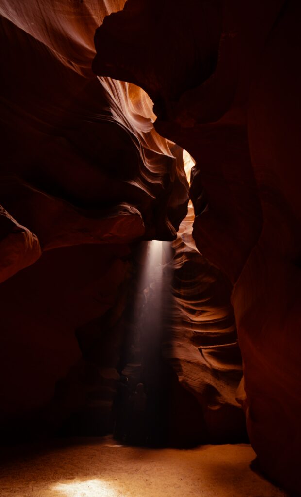 Sunlit rugged stone cavern with dark shadows highlighting serene canyon landscape wallpaper