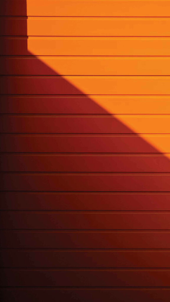 Glowing Horizons: Captivating Metal Texture with a Vibrant Sunlit Effect - A Striking iOS 16 Wallpaper