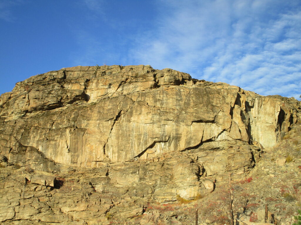 Sunlit rugged canyon walls and textured rocks in Tonasket Washington under clear blue sky wallpaper