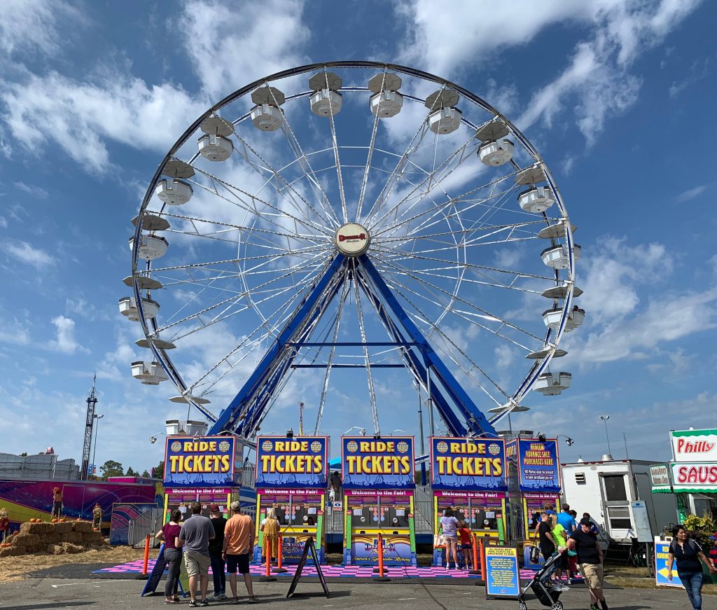 Vibrant fairground scene with Dreamland Ferris wheel bright sky and colorful ticket booths Wallpaper