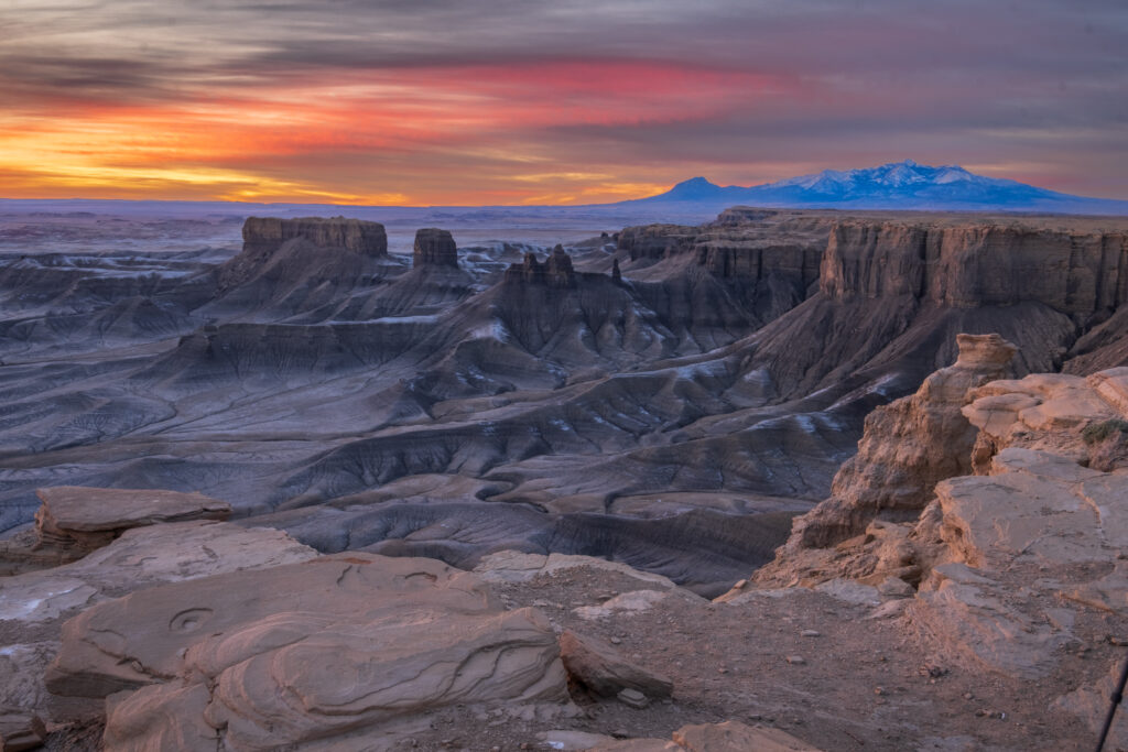 Sunrise canyon landscape with rugged rocks snow-capped mountains and dramatic sky wallpaper