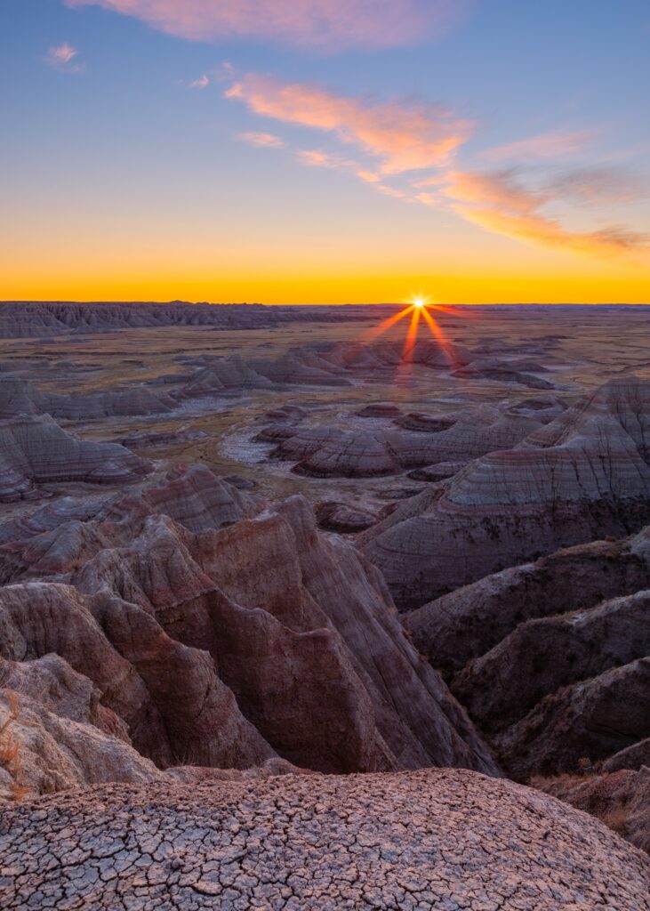 Sunset canyon landscape with rugged rocks dry cracked earth and warm golden purple hues wallpaper