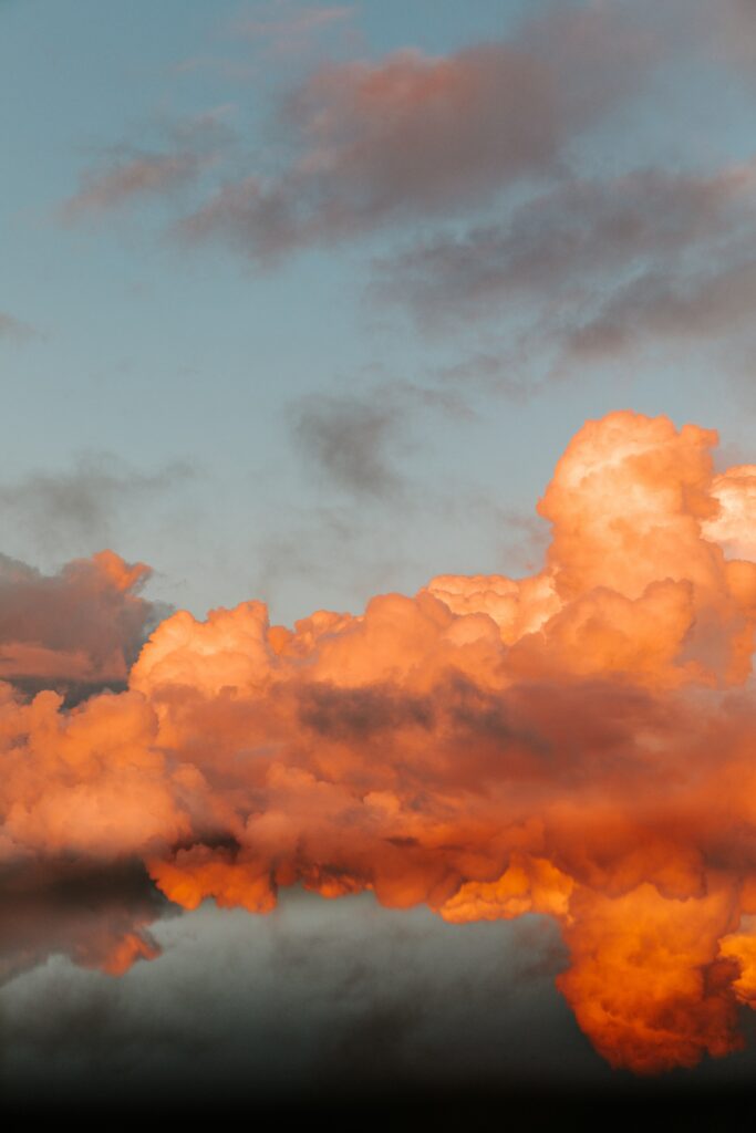 Sunset clouds in vivid orange and gold reflected in calm water peaceful nature wallpaper