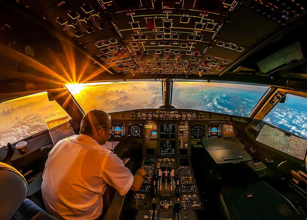 Sunset cockpit view airplane controls pilot vivid golden orange sky clouds aviation wallpaper