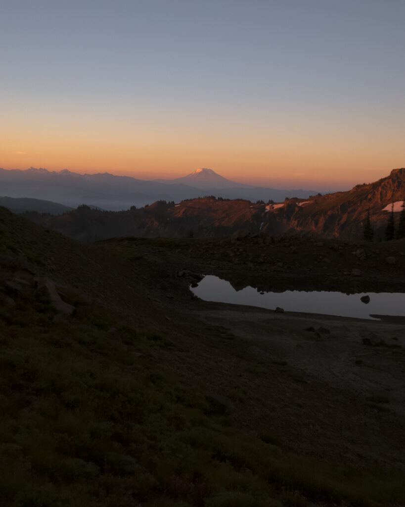 Sunset mountain landscape with orange pink sky reflected in still water pool serene wallpaper