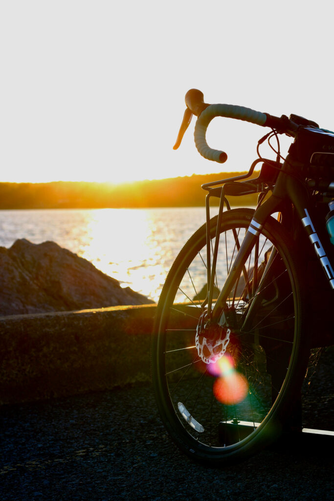 Close-up of modern road bike by ocean sunset with warm golden sky perfect for cycling fans Wallpaper