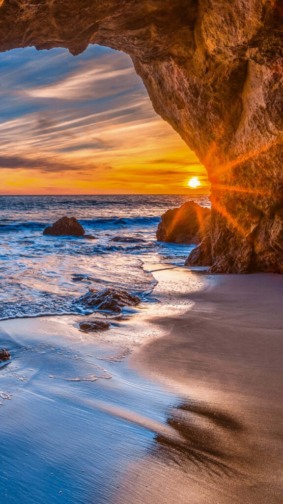 Scenic Serenity: Captivating Sunset Reflections in Malibu's Coastal Cave Wallpaper