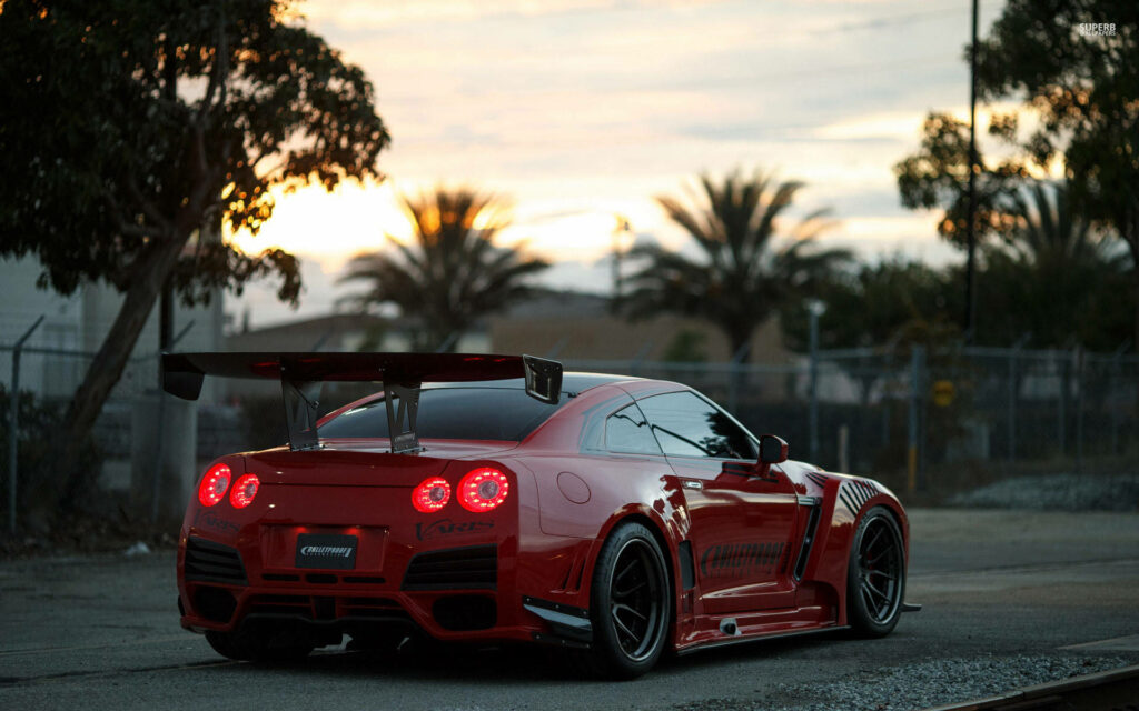Revving into the Sunset: Red Nissan GTR Sports Car Wallpaper