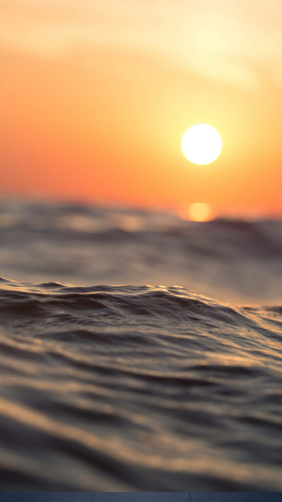 Golden Hour Serenity: Captivating 4k HD Ocean Waves and Setting Sun on Mobile Wallpaper