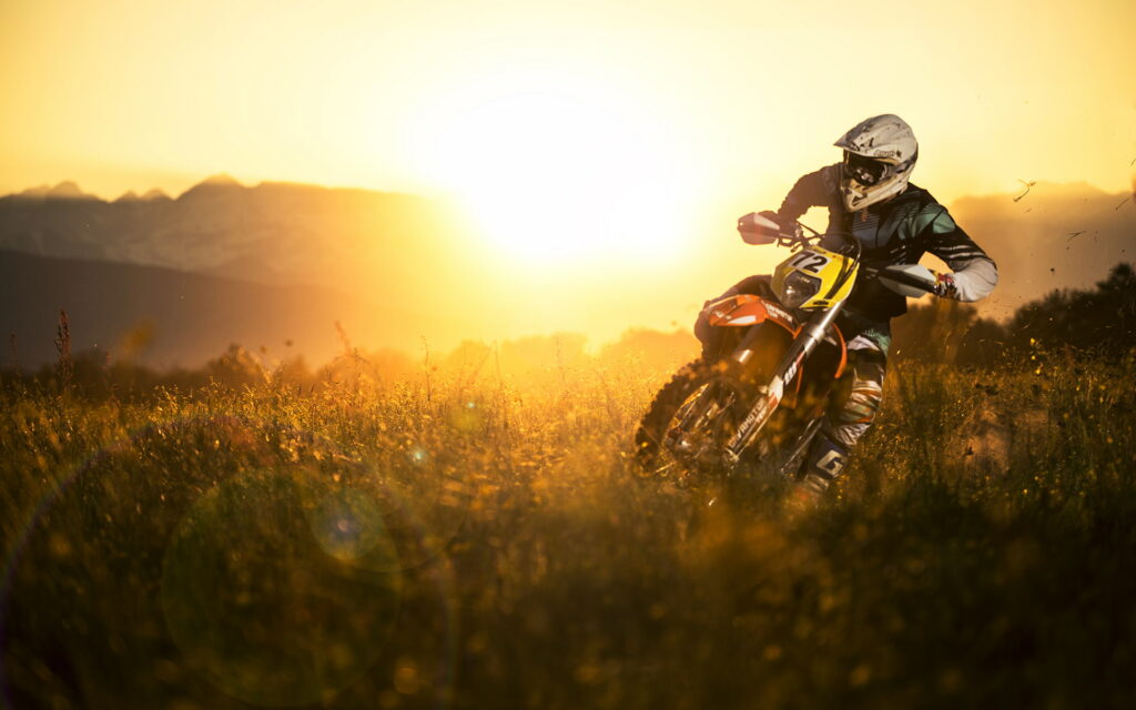 Sunset Thrills: HD Wallpaper Featuring a Dirtbike Motorcycle in the Golden Sunlight