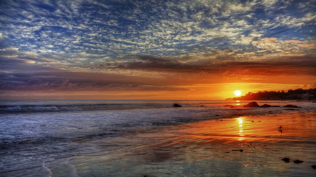 Serenity at Sunset: Captivating 1440p Scattered Clouds Over Malibu Beach Wallpaper