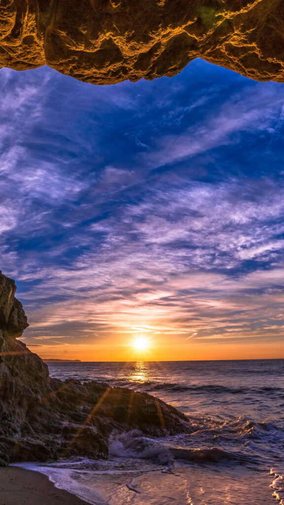 Sunset Serenade: Malibu Delights with Majestic Rocky Cave View Wallpaper