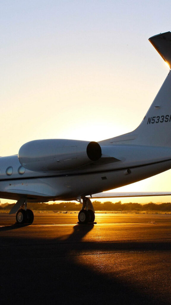 Sunset Soaring: Captivating White Jet Ablaze in Stunning iPhone Background Wallpaper