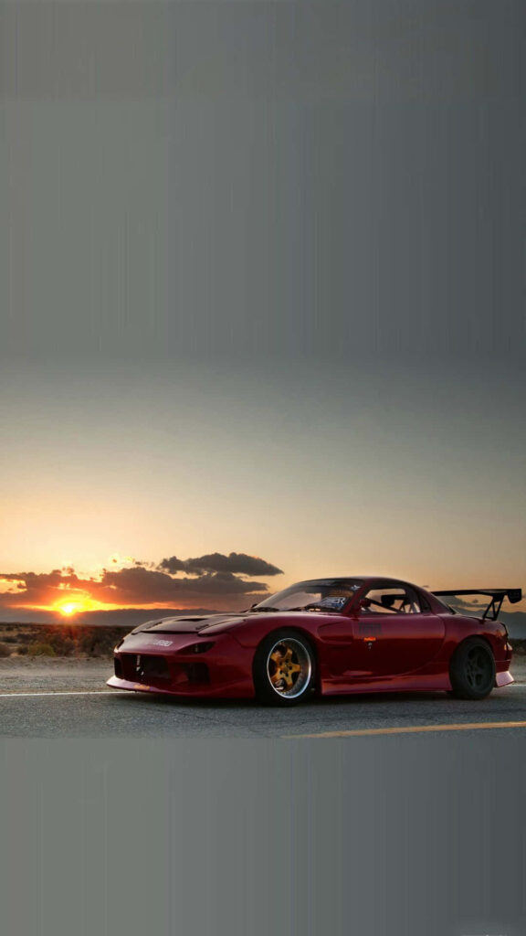 Speed and Style: A Captivating Sunset Scene with the Iconic Red Mazda RX 7 Wallpaper