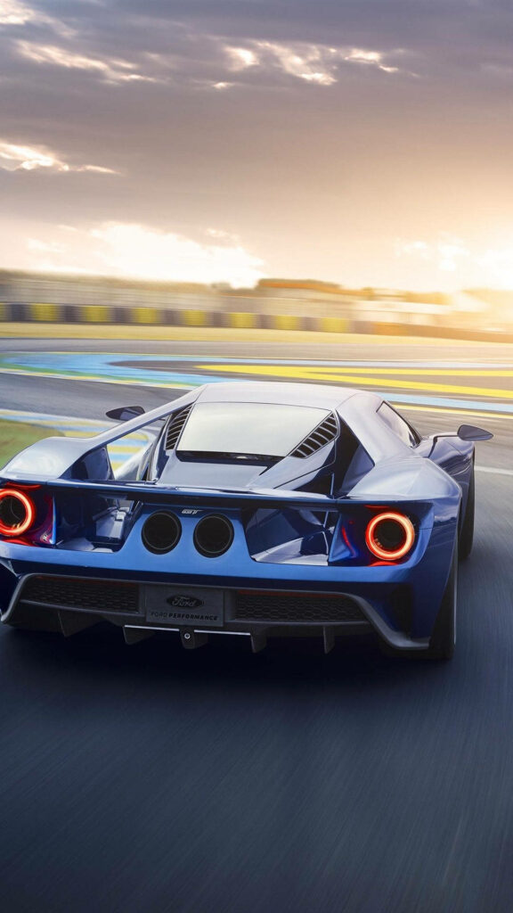 Roaring Towards the Horizon: Striking Indigo Ford Race Car Captured as a Thrilling Ford Iphone Background Wallpaper