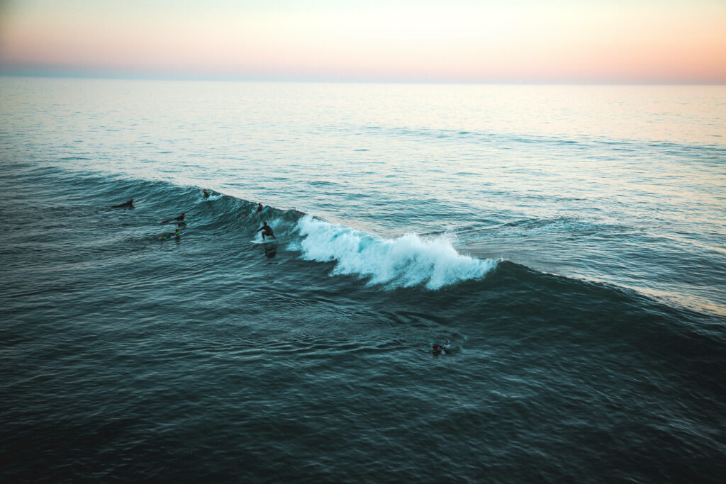 Ocean Bliss: Captivating PC Background featuring a Breathtaking Wave and Adventurous Surfers Wallpaper