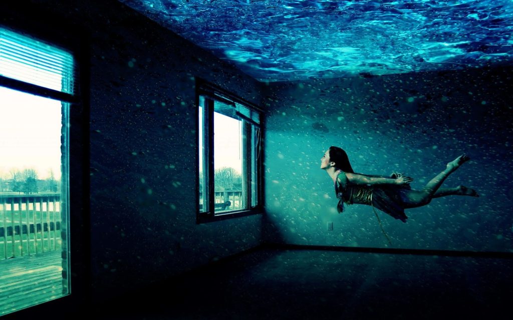 Surreal digital art of woman swimming in flooded deep blue room with caustic lighting effects Wallpaper
