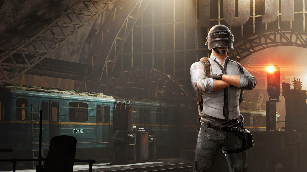 PUBG crossover wallpaper with character in Level 3 helmet at moody industrial train station background