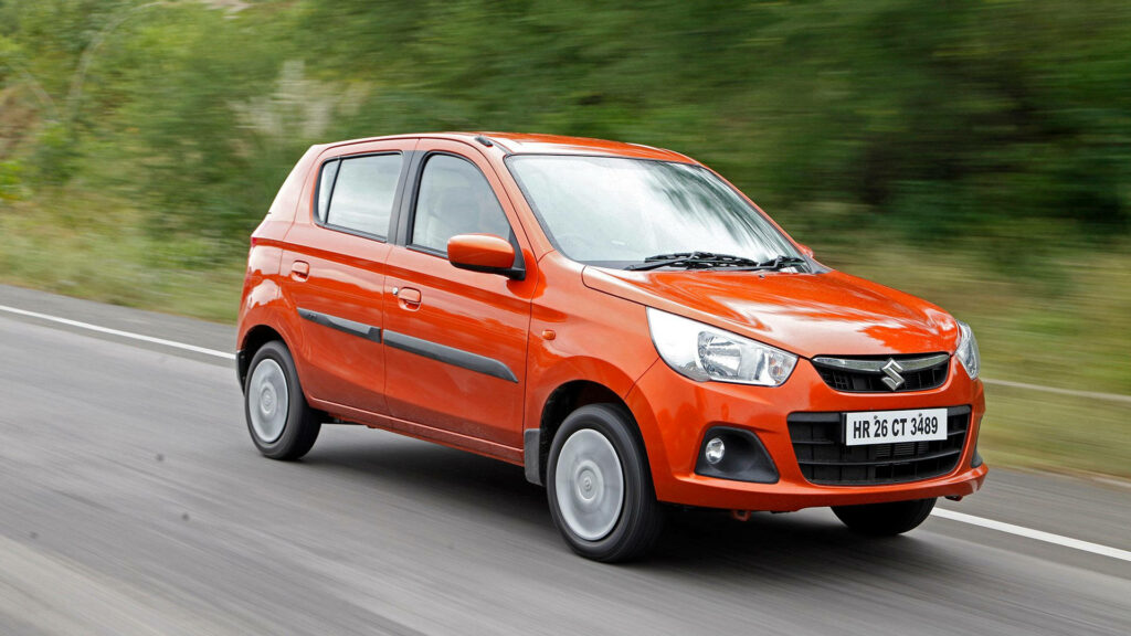 Stunning Suzuki Alto Wallpaper: Sleek Orange Design in Lush Greenery