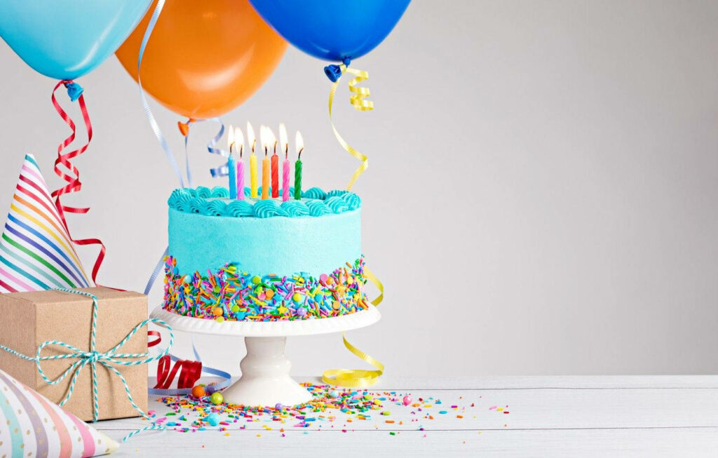 Indulging in Sweet Celebrations: Irresistible Blue Icing and Lively Sprinkles Enchanting a Birthday Cake Wallpaper