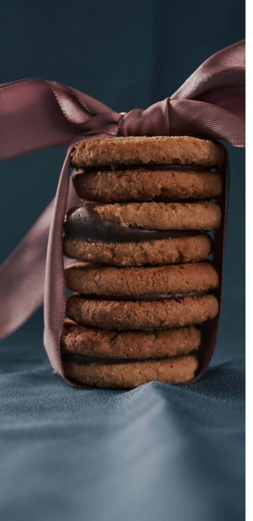 Delightful Cookie Stack Anchored by a Dainty Pink Ribbon on a Soft Fabric Canvas Wallpaper
