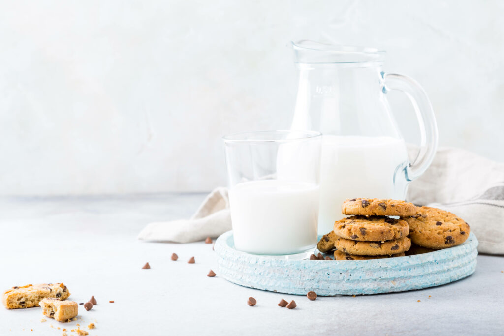 Sweet Indulgence: A Delectable Composition of Homemade Chocolate Chip Cookies and Refreshing Milk Wallpaper
