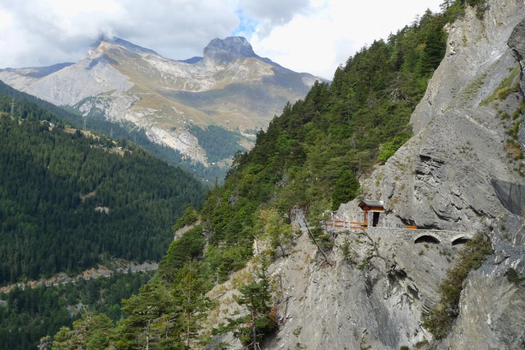 Scenic Swiss mountain landscape with green forests rocky cliffs wooden platform and valley view Wallpaper
