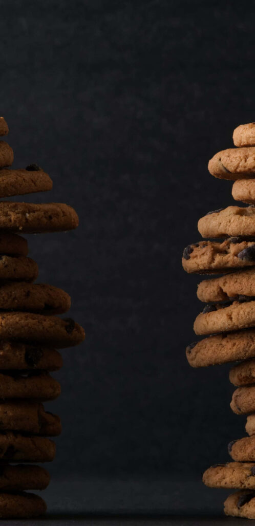 Tempting Stacks of Chocolate Chip Cookies Frame a Sleek Gray Canvas Wallpaper
