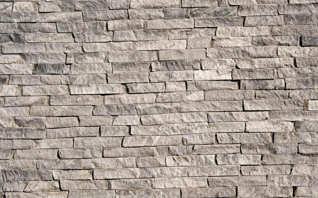 Rugged grey stone wall cladding textured wallpaper with horizontal stacked slate design and natural tones